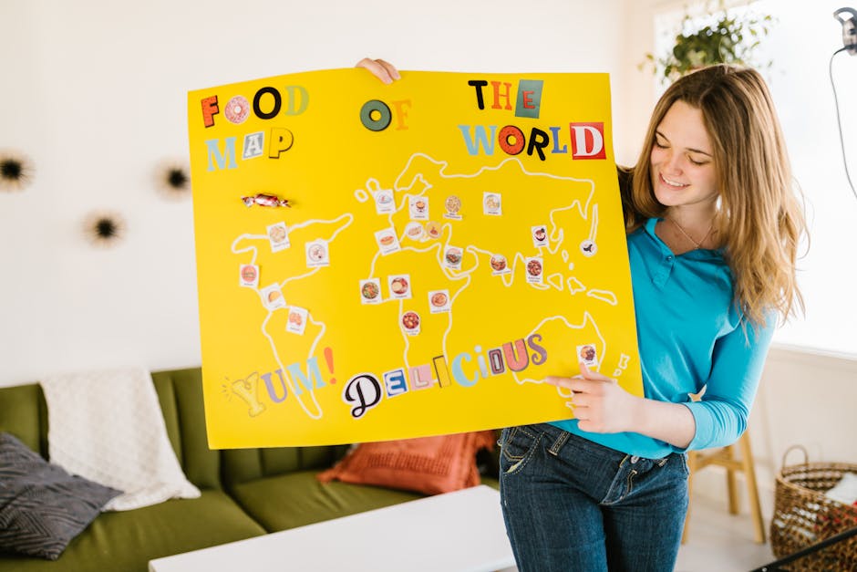 A woman indoors holding a vibrant food map craft, showcasing culinary diversity.